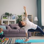 a woman and a child doing yoga in a living room